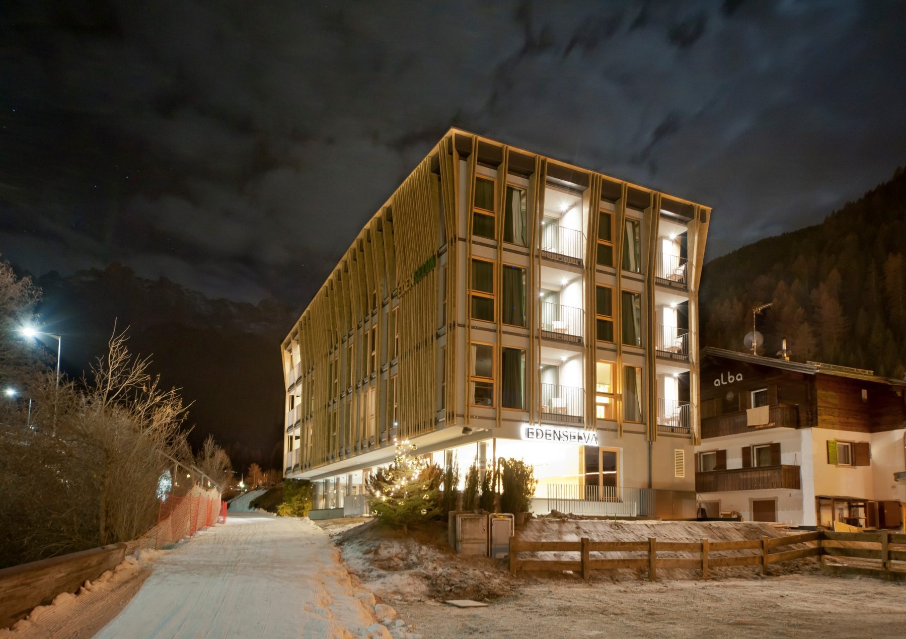 Das Hotel Eden bei Nacht, mit beleuchteter Holzfassade